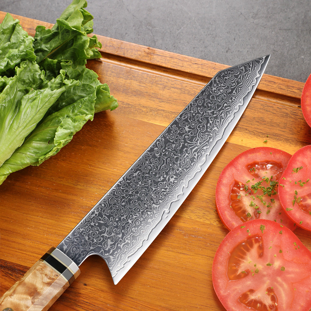 Damascus knife on a wooden cutting board with lettuce and tomatoes