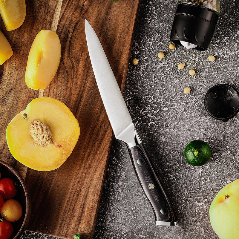 Knife on a wooden cutting board with sliced fruit and small containers on a gray surface