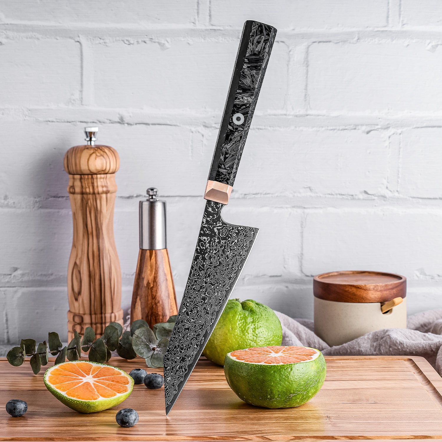 Petty knife with a decorative handle on a wooden cutting board with fruits and kitchen items.
